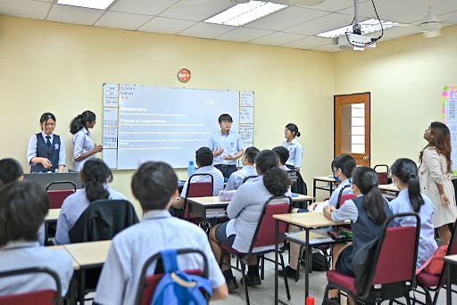 リージェント・インターナショナルスクール・スンガイ・プタニ: Student confidently presenting a project to classmates, showcasing communication and leadership skills